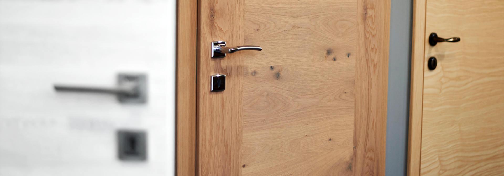 srebrna kljuka na lesenih notranjih vratih